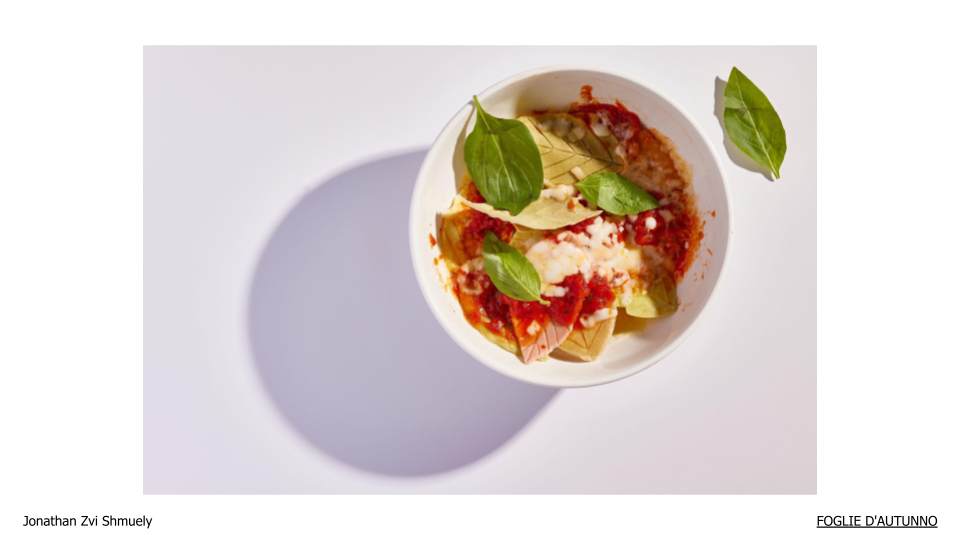 Bowl of cooked leaf pasta with tomato sauce and basil