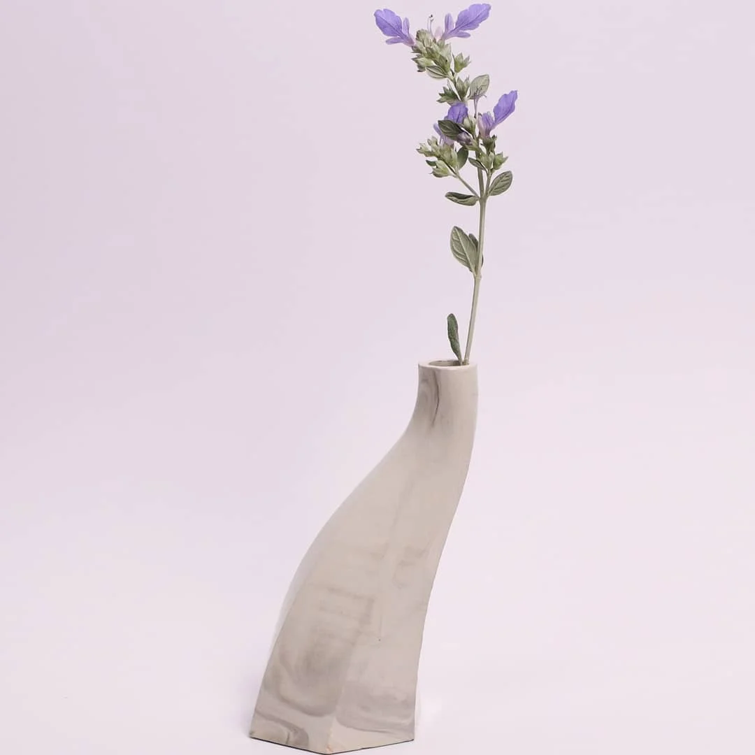 Single twisted ceramic vase with a sprig of flowers